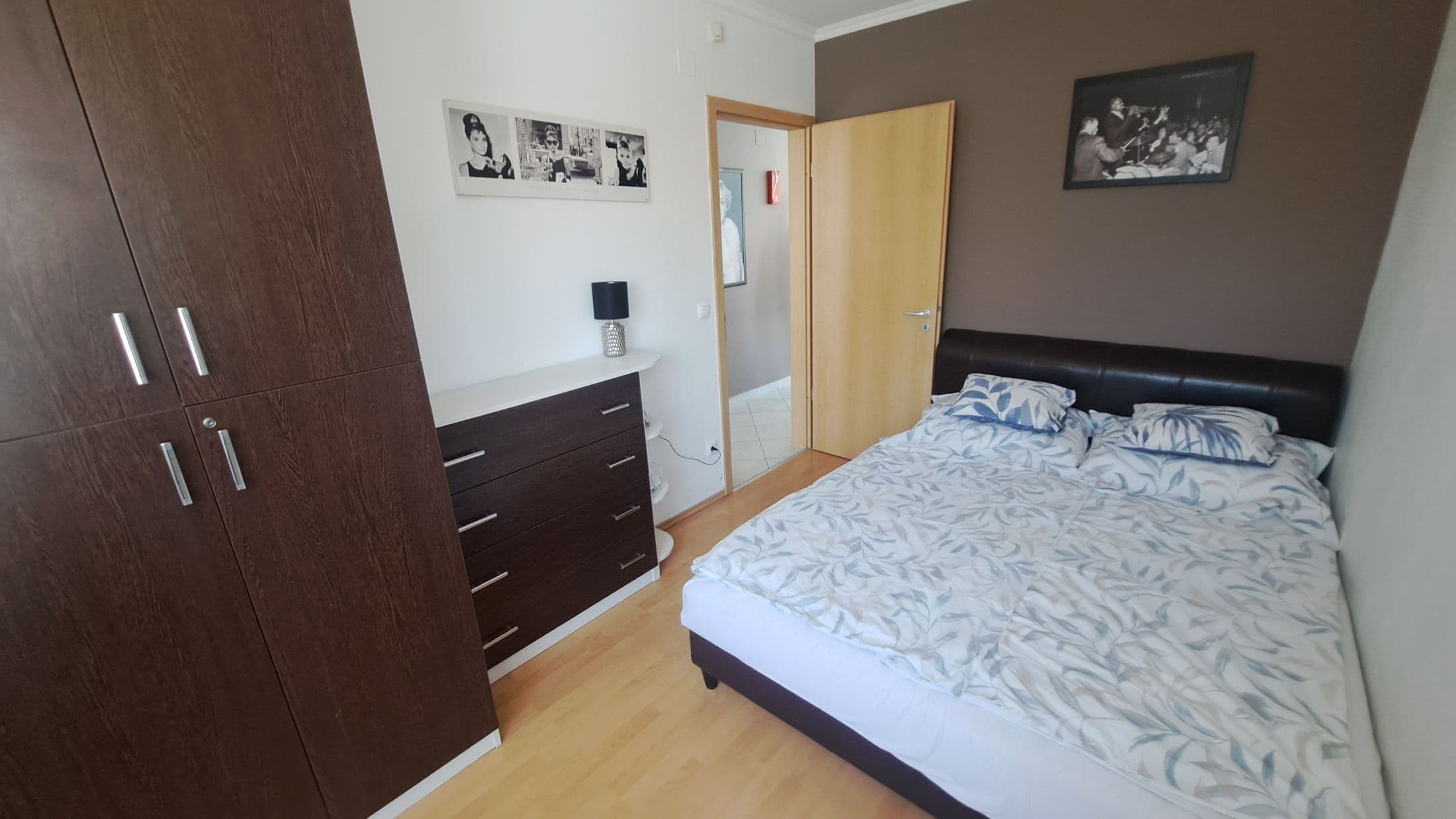 A Deluxe nagy hálószobája széles franciaággyal és sötét fa szekrénnyel